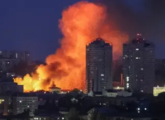 Пожары, поврежденные дома и автомобили. Reuters показало кадры ночных ударов РФ по Киеву — фоторепортаж